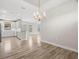 Open dining and kitchen area with wood flooring and a stylish chandelier at 11354 Callisia Dr, Odessa, FL 33556