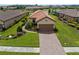Charming single-story home featuring a tile roof, well-manicured lawn, and a two-car garage with brick-paved driveway at 11354 Callisia Dr, Odessa, FL 33556