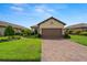 Lovely home with a brick driveway, two-car garage, and beautifully landscaped front yard with a tile roof at 11354 Callisia Dr, Odessa, FL 33556