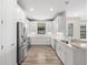Well-lit kitchen with stainless steel appliances, white cabinets, and ample counter space at 11354 Callisia Dr, Odessa, FL 33556