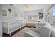 Well-lit Bedroom with three cribs, hardwood floors, and a comfortable rocking chair at 11720 80Th Ave, Seminole, FL 33772