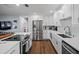 Bright kitchen featuring stainless steel appliances, white cabinetry, and center island with dark wood floors at 11720 80Th Ave, Seminole, FL 33772