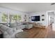 Spacious living room featuring a comfortable gray sectional sofa, a large window, and wood floors at 11720 80Th Ave, Seminole, FL 33772