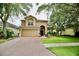 Charming two-story home featuring a brick driveway, attached two car garage, and landscaped front yard at 11821 Easthampton Dr, Tampa, FL 33626