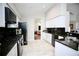 Modern kitchen with white cabinets, granite countertops, stainless steel appliances and tile floors at 11821 Easthampton Dr, Tampa, FL 33626
