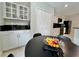 Well-lit kitchen with modern cabinetry and black countertops, complemented by a round dining table with fruit at 11821 Easthampton Dr, Tampa, FL 33626