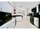 Modern kitchen with white cabinets, granite countertops, stainless steel appliances and tile floors at 11821 Easthampton Dr, Tampa, FL 33626
