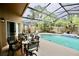 Relaxing screened-in pool area with outdoor dining set, sun loungers, and lush landscaping at 11821 Easthampton Dr, Tampa, FL 33626