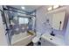 Well-lit bathroom with a shower and tub featuring stylish blue and white patterned tile and modern fixtures at 1200 47Th St N, St Petersburg, FL 33713