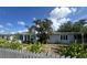Charming single-story home with a lush front yard, garden beds, and a white picket fence at 1200 47Th St N, St Petersburg, FL 33713