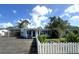 Inviting single-story home featuring a covered carport, well-kept lawn, and white picket fence at 1200 47Th St N, St Petersburg, FL 33713