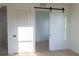 Bright bedroom featuring light wood floors, white walls, lots of natural light, and modern barn door at 1218 E Kay St # 21, Tampa, FL 33602