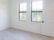 Bright bedroom with two windows, neutral colored walls, and light wood flooring at 1218 E Kay St # 21, Tampa, FL 33602