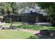 Beautiful backyard with screened-in pool, lounge chair, patio and fire pit at 12929 Sugar Creek Blvd, Hudson, FL 34669