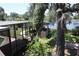 Scenic backyard featuring lush landscaping, pool, outdoor kitchen, and tranquil lake views at 12929 Sugar Creek Blvd, Hudson, FL 34669