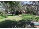 Spacious backyard featuring large trees and a screened in back porch at 12929 Sugar Creek Blvd, Hudson, FL 34669