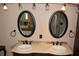 Bathroom featuring double sink vanity, framed mirrors, and pendant lights at 12929 Sugar Creek Blvd, Hudson, FL 34669