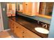 Bathroom featuring wood cabinets, black granite counters, and decorative towels at 12929 Sugar Creek Blvd, Hudson, FL 34669