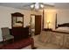 Bedroom features hardwood floors, a ceiling fan, sitting area and a four poster bed at 12929 Sugar Creek Blvd, Hudson, FL 34669