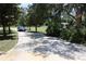 Long driveway leading to a home with mature trees and a well-maintained lawn at 12929 Sugar Creek Blvd, Hudson, FL 34669