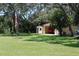 Exterior view of garage with car inside on a beautiful lawn with an American flag in the yard at 12929 Sugar Creek Blvd, Hudson, FL 34669