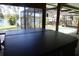 A view of the screened-in porch area and the pool overlooking the lake beyond the manicured lawn at 12929 Sugar Creek Blvd, Hudson, FL 34669