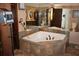 Jetted tub in a tiled bathroom with natural light and dark fixtures at 12929 Sugar Creek Blvd, Hudson, FL 34669