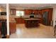 Well-lit kitchen boasts ample counter space, wooden cabinetry, and an island with seating at 12929 Sugar Creek Blvd, Hudson, FL 34669