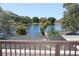Expansive lake view from the screened porch, framed by lush trees and a serene blue sky at 12929 Sugar Creek Blvd, Hudson, FL 34669