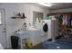 Functional laundry area with washer, dryer, and shelving, adjacent to the garage at 12929 Sugar Creek Blvd, Hudson, FL 34669