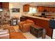 Living area featuring a stone fireplace, leather seating, and adjacent kitchen with granite counters at 12929 Sugar Creek Blvd, Hudson, FL 34669