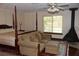 Comfortable sitting area beside the four-poster bed within the naturally lit main bedroom at 12929 Sugar Creek Blvd, Hudson, FL 34669