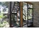 This screened-in patio features stone accents, access to the yard, and stairs that lead to the upper level at 12929 Sugar Creek Blvd, Hudson, FL 34669