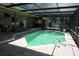 The screened-in pool area with a spacious patio and cozy seating, ideal for entertaining and enjoying sunny days at 12929 Sugar Creek Blvd, Hudson, FL 34669