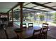 Inviting screened-in pool area with comfortable seating, a dining table, and a serene view of the adjacent lake at 12929 Sugar Creek Blvd, Hudson, FL 34669
