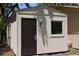 Exterior view of a shed featuring a brown door and window at 12929 Sugar Creek Blvd, Hudson, FL 34669