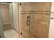 Shower with glass door and tile surround in neutral earth tones at 12929 Sugar Creek Blvd, Hudson, FL 34669