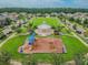 Aerial view of a green community park with a playground, gazebo, and walking paths in a neighborhood at 13311 Dorado Shores Ave, Riverview, FL 33579