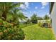 Backyard featuring a beautiful black metal fence, lush plants, and a well-maintained lawn at 13311 Dorado Shores Ave, Riverview, FL 33579