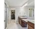 Bathroom featuring dual granite countertop sinks, dark wood cabinets and glass door shower at 13311 Dorado Shores Ave, Riverview, FL 33579