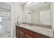 Bathroom vanity with granite countertop, wood cabinets, and shower with glass door at 13311 Dorado Shores Ave, Riverview, FL 33579