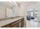 Bathroom showcasing granite vanity, sink, modern fixtures, and open to living area at 13311 Dorado Shores Ave, Riverview, FL 33579