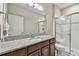 Bathroom with granite counters, wood cabinets and a glass enclosed shower at 13311 Dorado Shores Ave, Riverview, FL 33579