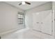 Well-lit bedroom with neutral walls and white tile flooring plus a double-door closet at 13311 Dorado Shores Ave, Riverview, FL 33579