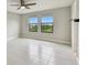 Bedroom with light gray tile flooring and view of trees outside the window at 13311 Dorado Shores Ave, Riverview, FL 33579