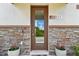 Charming entryway featuring a modern door, stone accents, and potted plants for a welcoming appeal at 13311 Dorado Shores Ave, Riverview, FL 33579