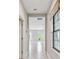 Bright hallway with neutral walls and modern white tile floors that lead into the home at 13311 Dorado Shores Ave, Riverview, FL 33579