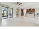 Open-concept living area with tile flooring, ceiling fan, and access to a screened patio and modern kitchen at 13311 Dorado Shores Ave, Riverview, FL 33579