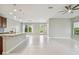Open living space with tile flooring, ceiling fan, and seamless transition to a modern kitchen area at 13311 Dorado Shores Ave, Riverview, FL 33579