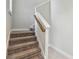 Carpeted staircase with white trim and natural wood handrail at 13311 Dorado Shores Ave, Riverview, FL 33579